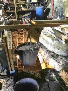 Fouille et extraction de la boue dans la salle d'eau au moulin de la Porte