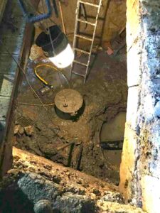 Fouille et extraction de la boue dans la salle d'eau au moulin de la Porte