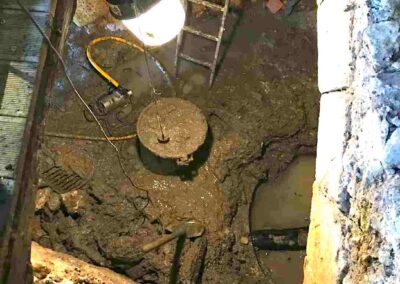 Fouille et extraction de la boue dans la salle d'eau au moulin de la Porte