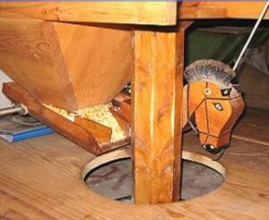 L'auget, frappé par le babillard guide et régule le débit du grain vers l'oeillard.(Hautes-Pyrénées)